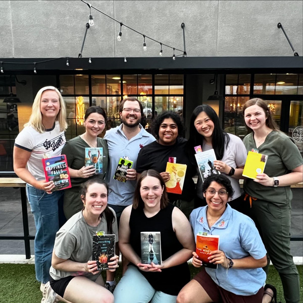 outdoor group picture of residents holding up books with bookmarks inserted